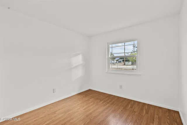 a view of a small space with wooden floor and a window