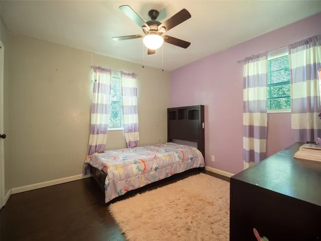a bedroom with a bed and a flat tv screen on dresser