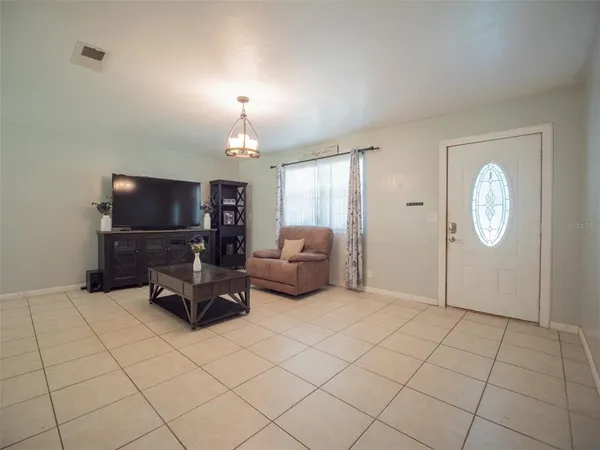 a living room with furniture a flat screen tv and kitchen view
