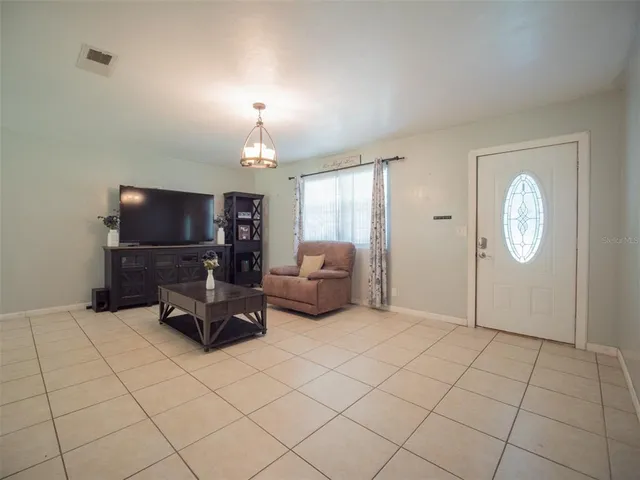 a living room with furniture a flat screen tv and kitchen view