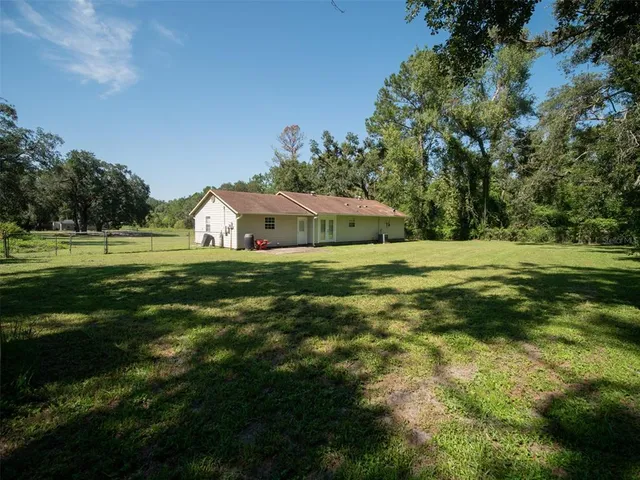 front view of house with a yard and trees