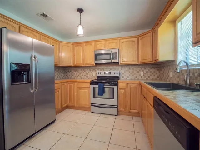 a kitchen with kitchen island granite countertop a stove a sink and a refrigerator