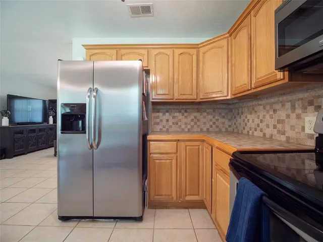 a kitchen with stainless steel appliances granite countertop a refrigerator a sink and dishwasher