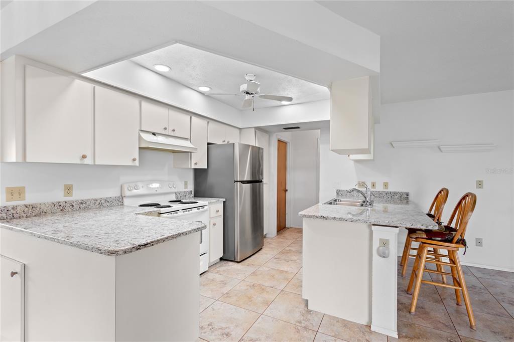 420 Duke Road Venice, FL 34293 - Photo 5 of 22 a kitchen with stainless steel appliances granite countertop a stove a sink a microwave and a refrigerator