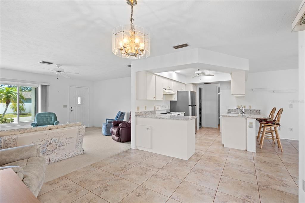 420 Duke Road Venice, FL 34293 - Photo 7 of 22 a very nice looking dining room with kitchen island stainless steel appliances furniture a chandelier a rug and a window