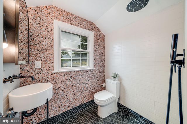 a bathroom with a toilet sink and mirror