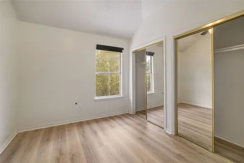 an empty room with wooden floor and a window
