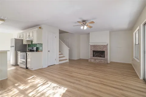 a view of empty room with wooden floor and fireplace
