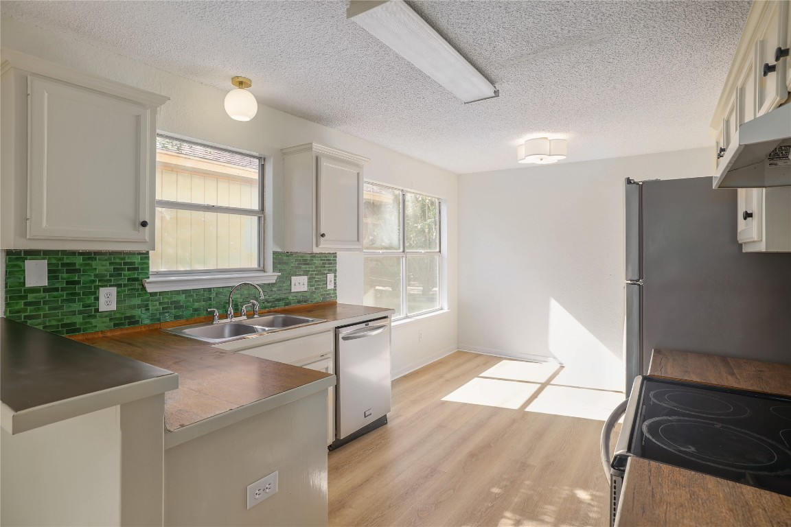 2229 Jasmine Path Round Rock, TX 78664 - Photo 8 of 28 a kitchen with a sink a stove a refrigerator and a window