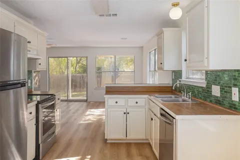 a kitchen that has a sink cabinets counter space and appliances