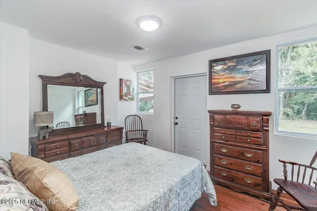 a bedroom with a bed and a dresser with mirror