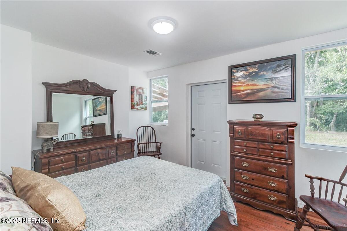 4636 Timuquana Road Jacksonville, FL 32210 - Photo 14 of 21 a bedroom with a bed and a dresser with mirror