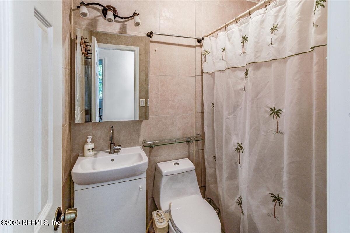 4636 Timuquana Road Jacksonville, FL 32210 - Photo 15 of 21 a bathroom with a sink a mirror a toilet and shower
