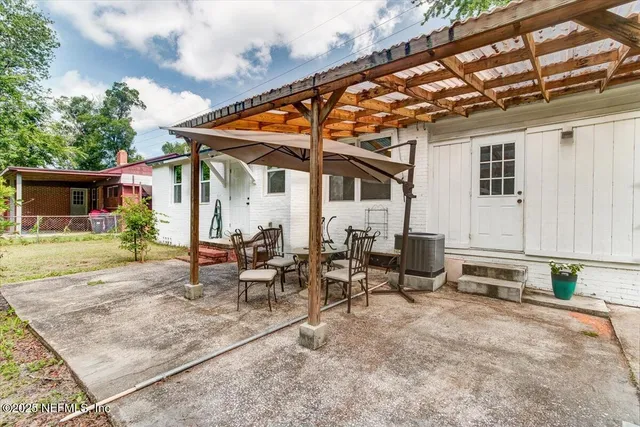 a view of patio with a table and chairs under an umbrella