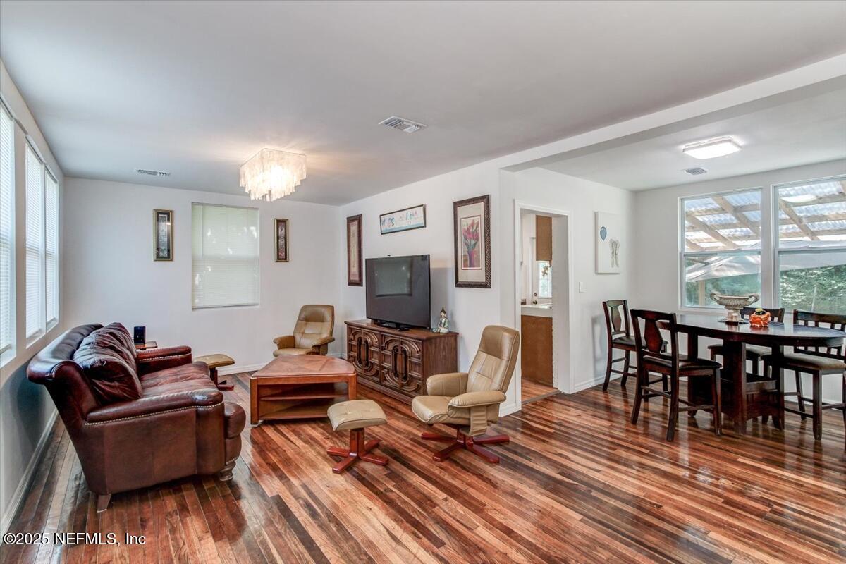 4636 Timuquana Road Jacksonville, FL 32210 - Photo 5 of 21 a living room with furniture a dining table and a floor to ceiling window