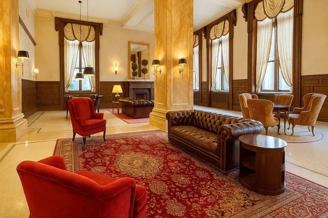 a living room with furniture a fireplace and large windows