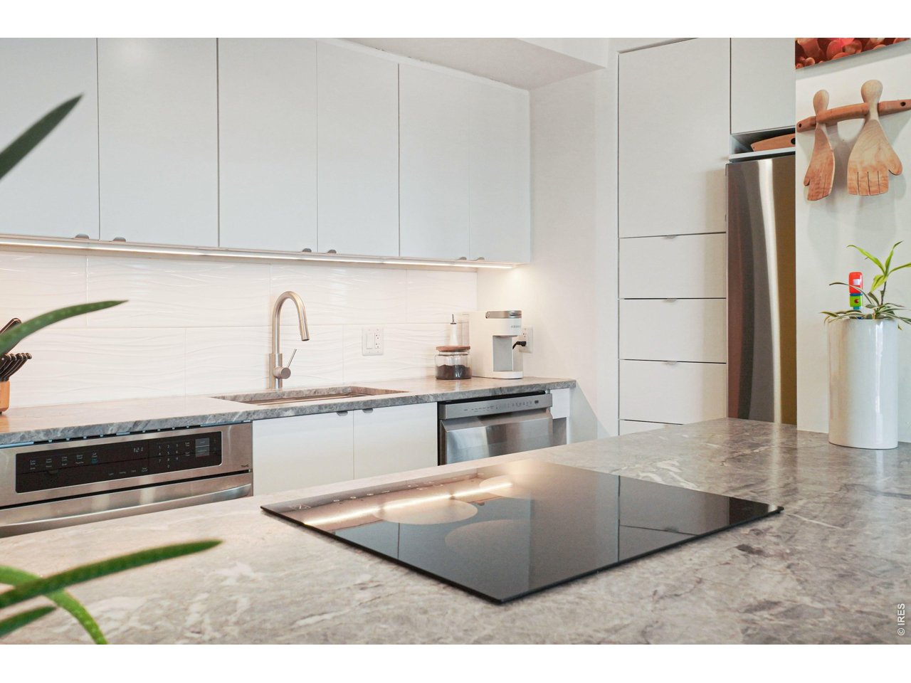 1020 15th Street, Unit 32L Denver, CO 80202 - Photo 11 of 32 a kitchen with stainless steel appliances granite countertop a sink stove and refrigerator