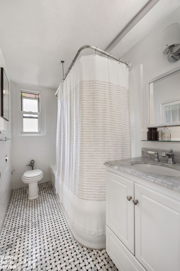 12 East 97th Street, Unit 2G Manhattan, NY 10128 - Photo 5 of 7 a bathroom with a sink a toilet and shower