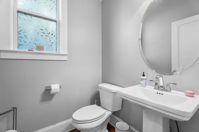 a bathroom with a toilet a sink and mirror