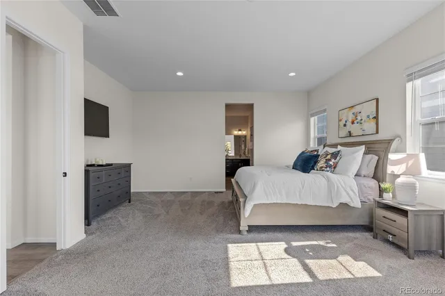 a spacious bedroom with a bed and a couch