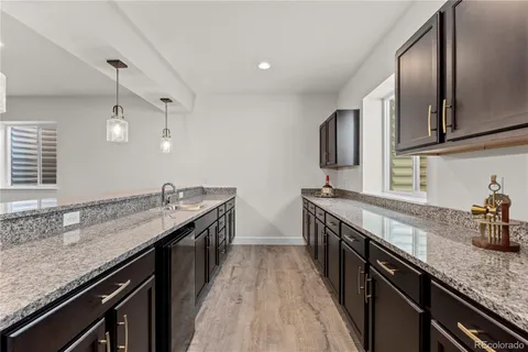 a kitchen with granite countertop stainless steel appliances a sink dishwasher a stove top oven a sink and dishwasher