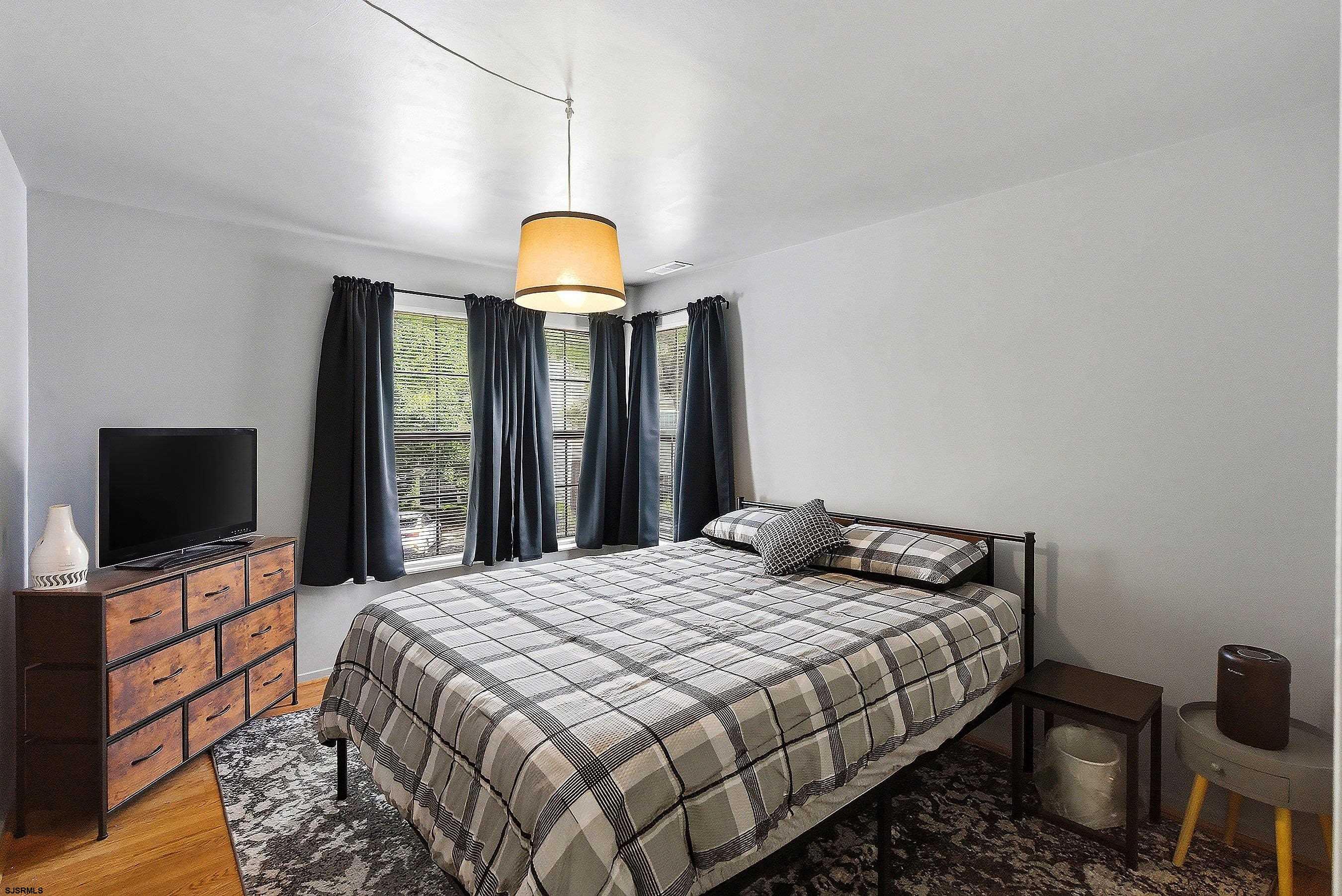 224 Meadow Ridge Road, Unit 224 Smithville, NJ 08205 - Photo 12 of 22 a bedroom with a bed and a flat screen tv