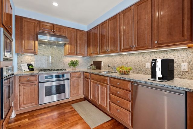 a kitchen with granite countertop stainless steel appliances and wooden cabinets