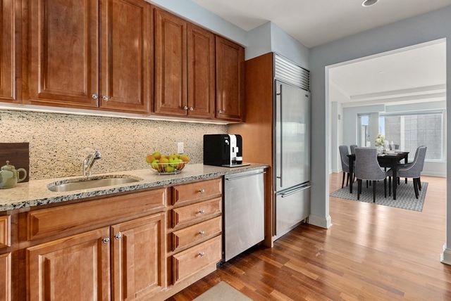a kitchen with stainless steel appliances granite countertop a refrigerator and a sink