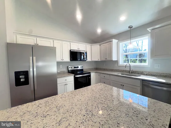 a kitchen with stainless steel appliances granite countertop a refrigerator stove microwave and sink