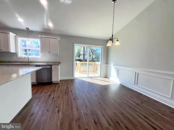 a kitchen with stainless steel appliances granite countertop wooden floors a stove and white countertops with wooden floor