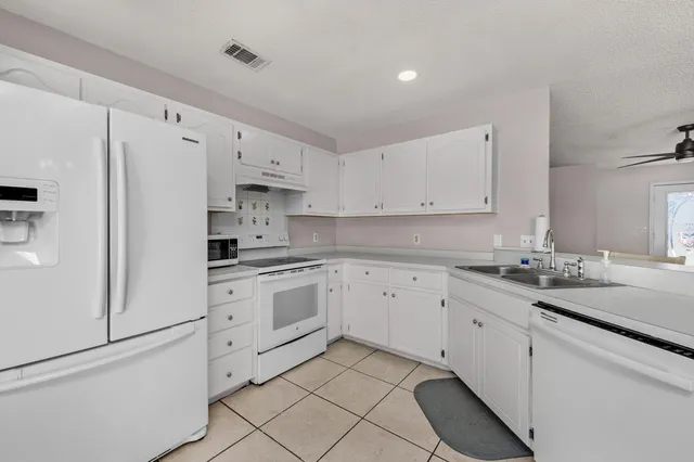 a kitchen with granite countertop white cabinets and white appliances