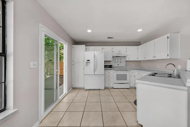 a kitchen with a sink a stove a refrigerator and cabinets