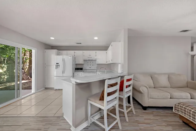 a living room with stainless steel appliances granite countertop furniture and a view of kitchen