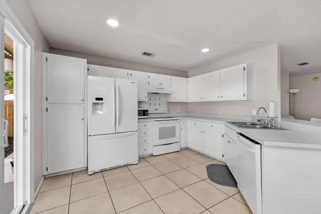 a kitchen with white cabinets stainless steel appliances and a sink
