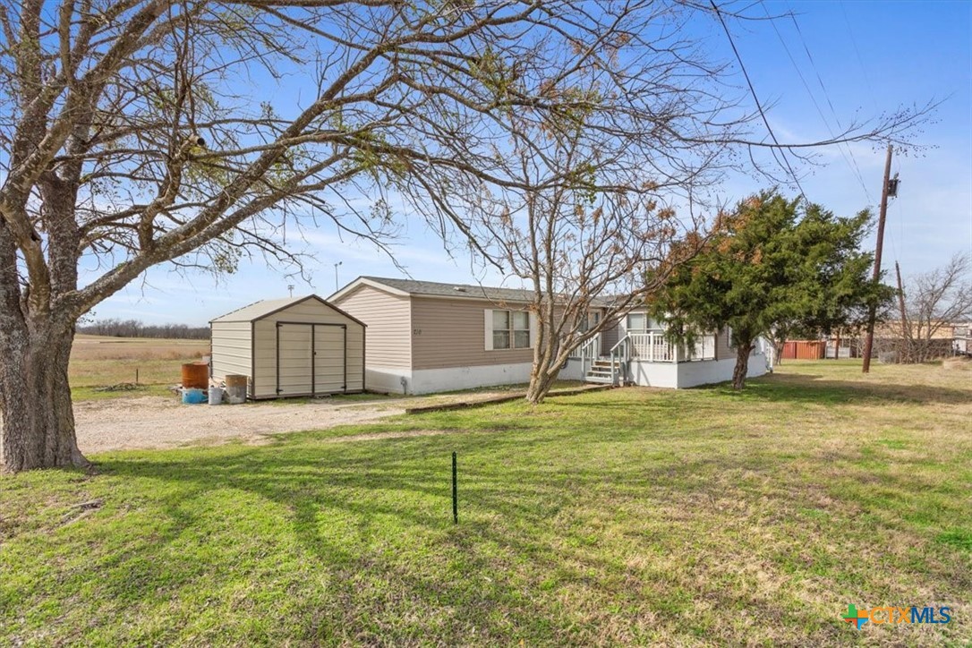 216 Moore Street Rogers, TX 76569 - Photo 2 of 29 a view of a yard in front of a house with large trees