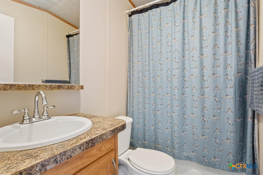 216 Moore Street Rogers, TX 76569 - Photo 21 of 29 a bathroom with a granite countertop sink toilet and shower