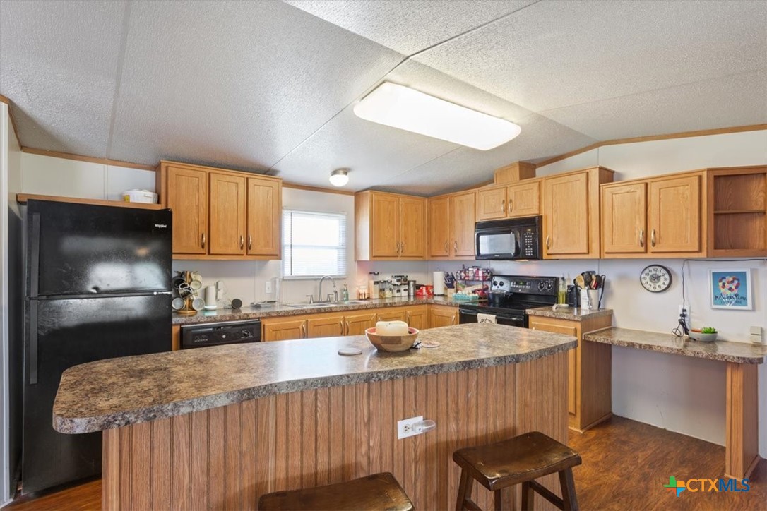216 Moore Street Rogers, TX 76569 - Photo 9 of 29 a kitchen with stainless steel appliances granite countertop a sink a stove a refrigerator cabinets and a window