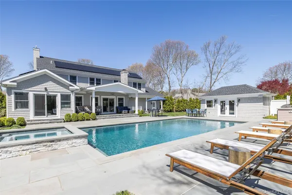a view of a house with pool and chairs