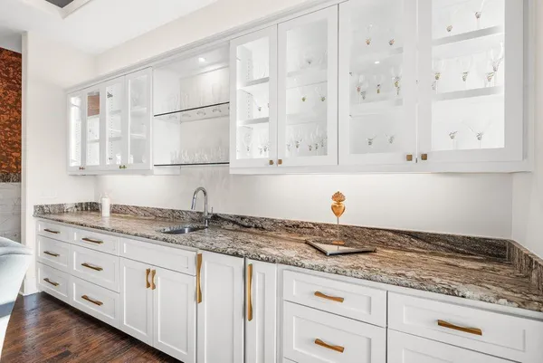 a kitchen with granite countertop white cabinets and sink