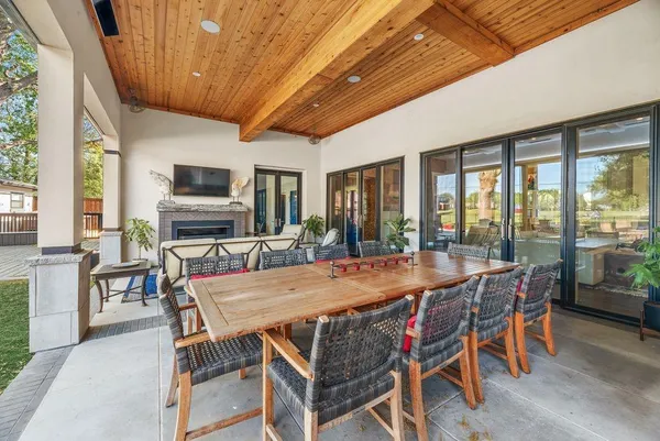 a living room with furniture a fireplace and a floor to ceiling window