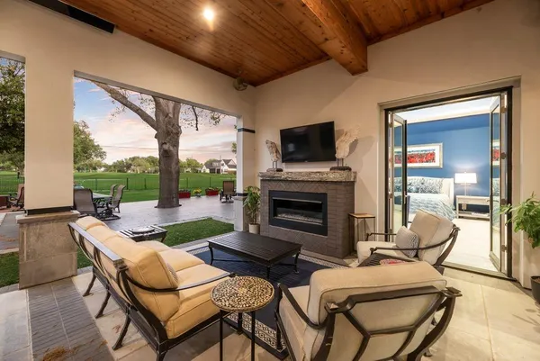 a living room with furniture a flat screen tv and a floor to ceiling window
