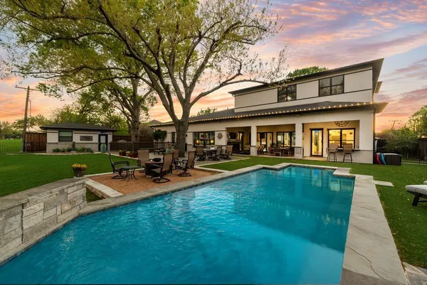 a view of a house with a yard chairs and table in the patio