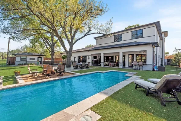 a front view of a house with swimming pool having outdoor seating
