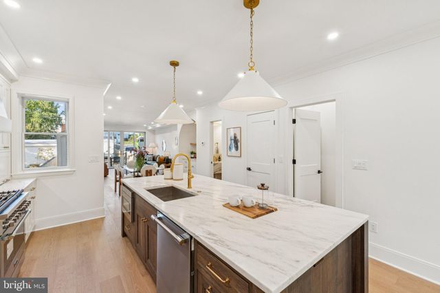 a kitchen with stainless steel appliances kitchen island a white counter space a sink and living room view