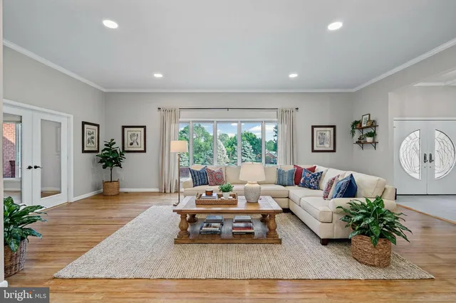 a living room with furniture a clock on wall and a table