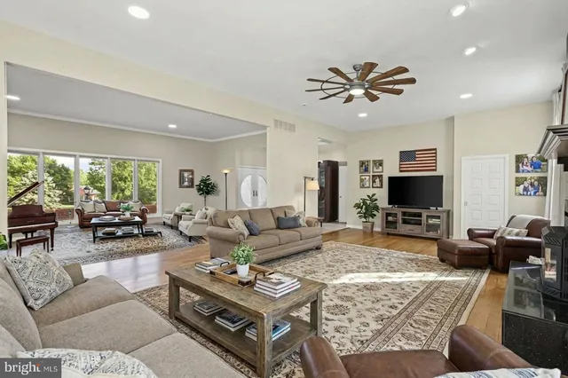 a kitchen with stainless steel appliances granite countertop a sink a stove a refrigerator cabinets and chairs