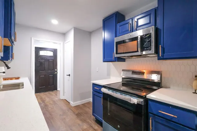 a kitchen with stainless steel appliances a stove microwave and sink