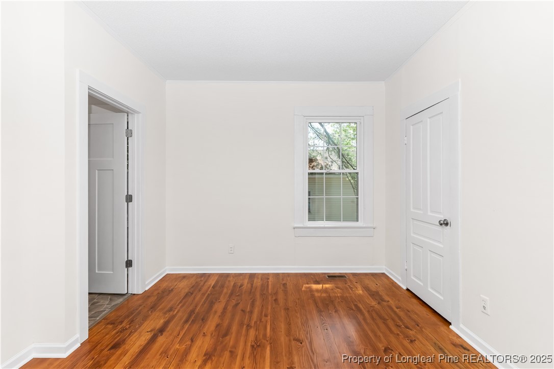 726 West M Street Erwin, NC 28339 - Photo 13 of 24 an empty room with wooden floor and windows
