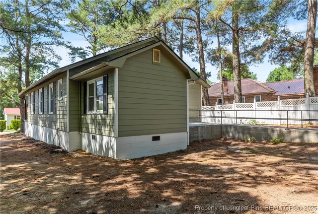 a front view of a house with a large tree