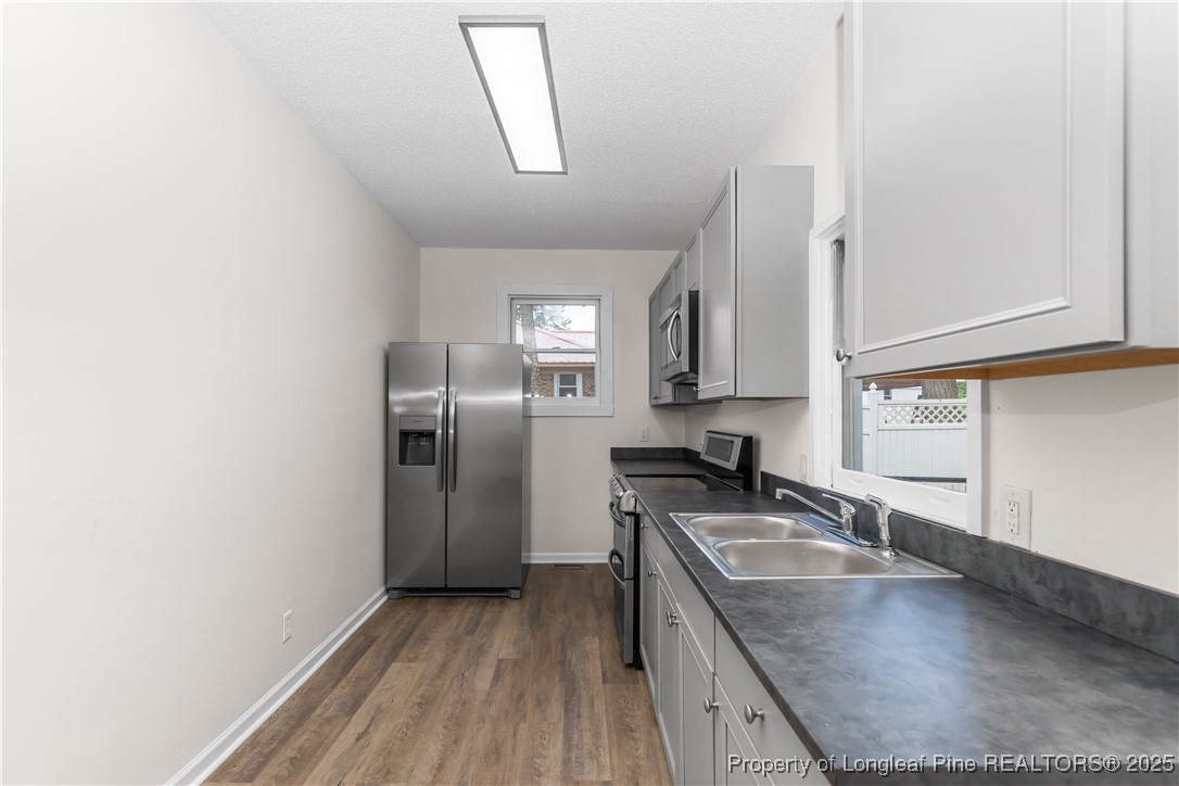 726 West M Street Erwin, NC 28339 - Photo 4 of 24 a kitchen with granite countertop a sink stove and refrigerator